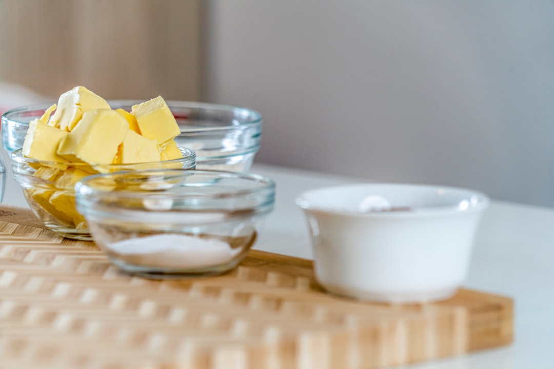 Cubed butter and sugar measured in glass bowls, ready for creaming in a stand mixer