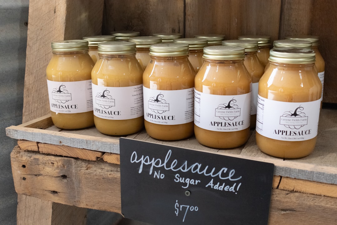 Glass jars of homemade applesauce lined up at a farm stand