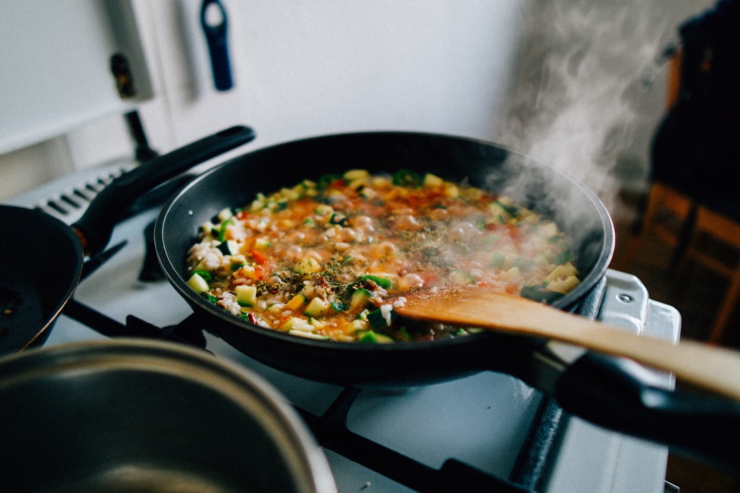 Vegetables and rice cooking in a black steel wok on the stovetop