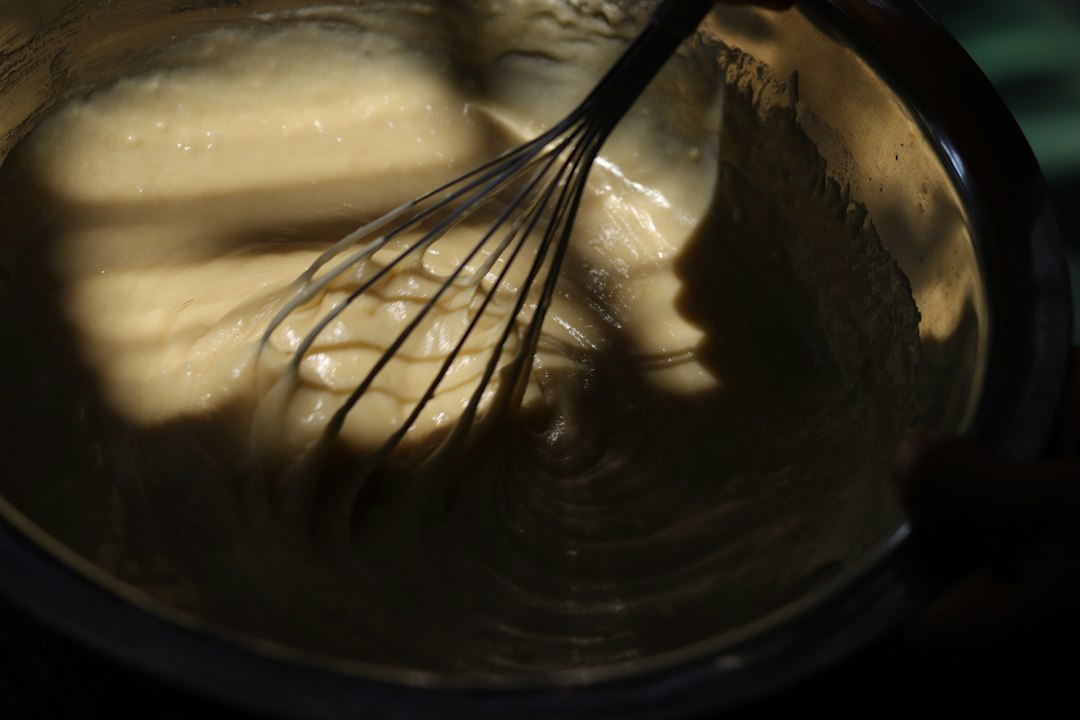 Whisking batter in a metal mixing bowl