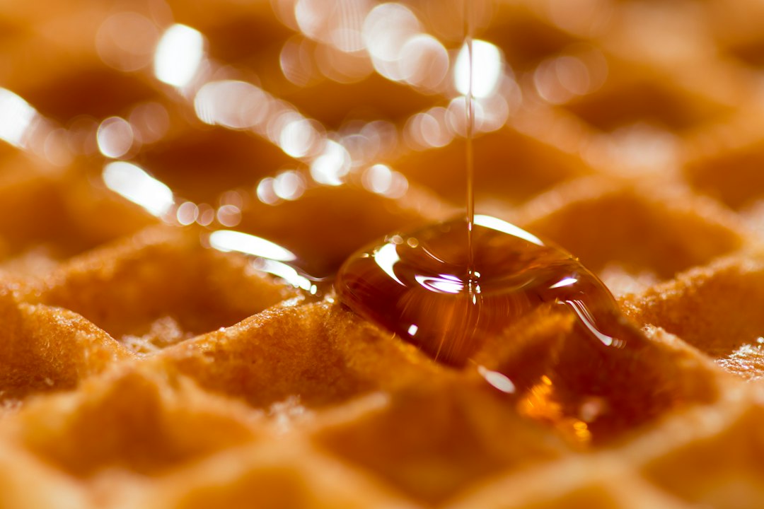 Stack of golden waffles drizzled with honey