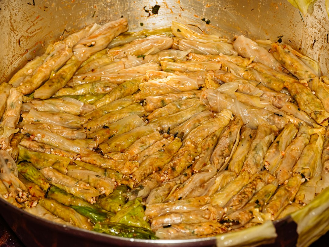 Braised rolled cabbage leaves simmering in a pan