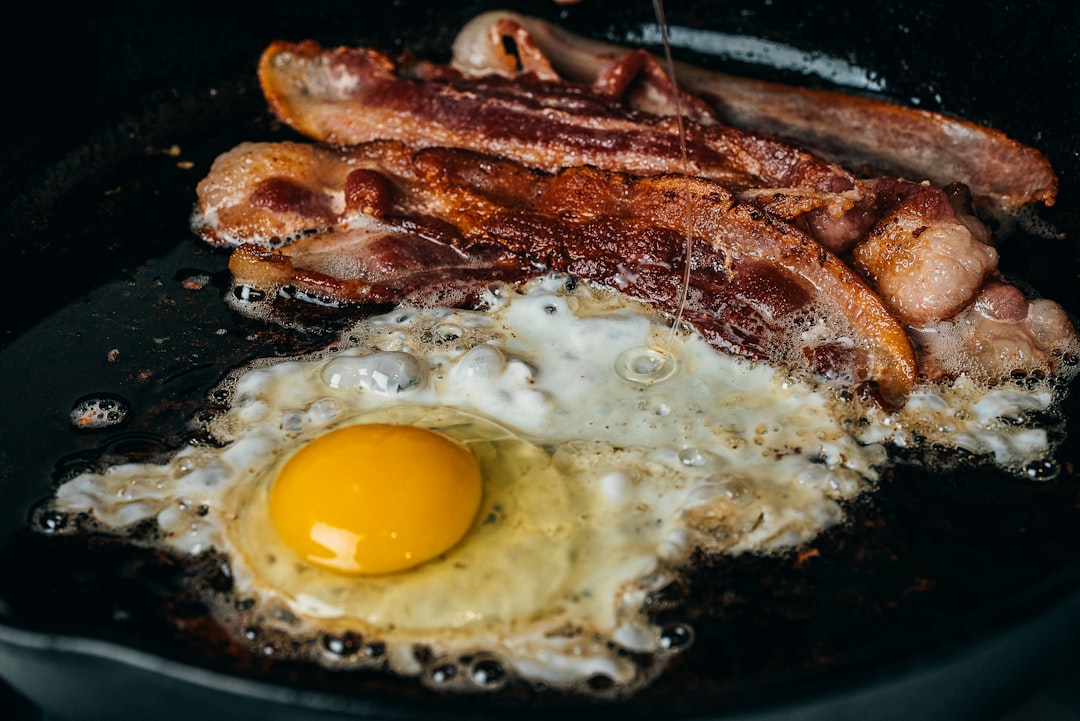 Bacon and eggs cooking in a cast iron skillet