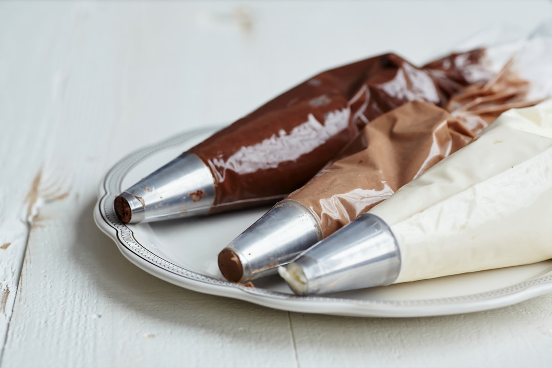 Filled icing bags in multiple colors staged on a plate before decorating