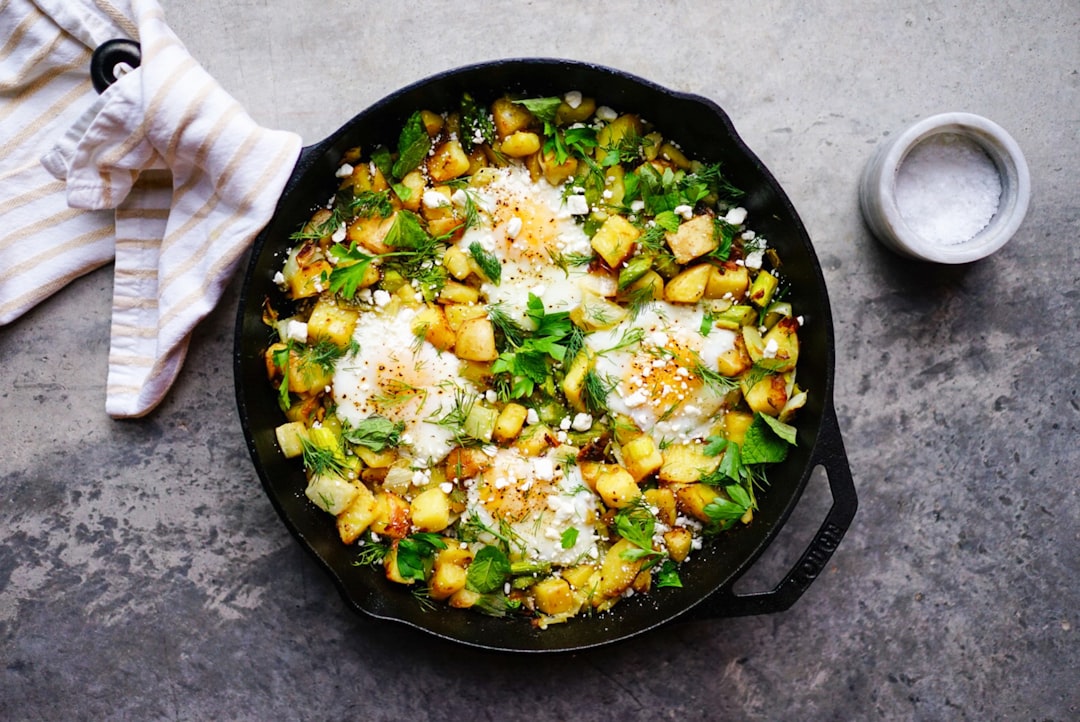 Crispy potatoes and eggs baked in a black cast iron skillet for breakfast