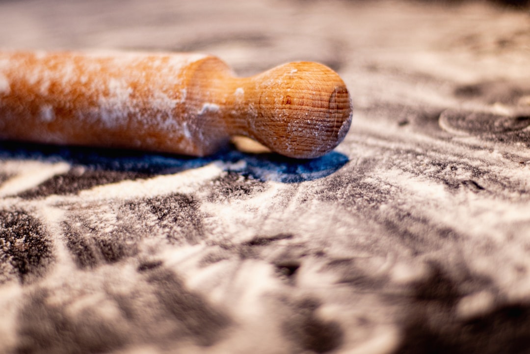 Wooden rolling pin resting on freshly rolled cookie dough