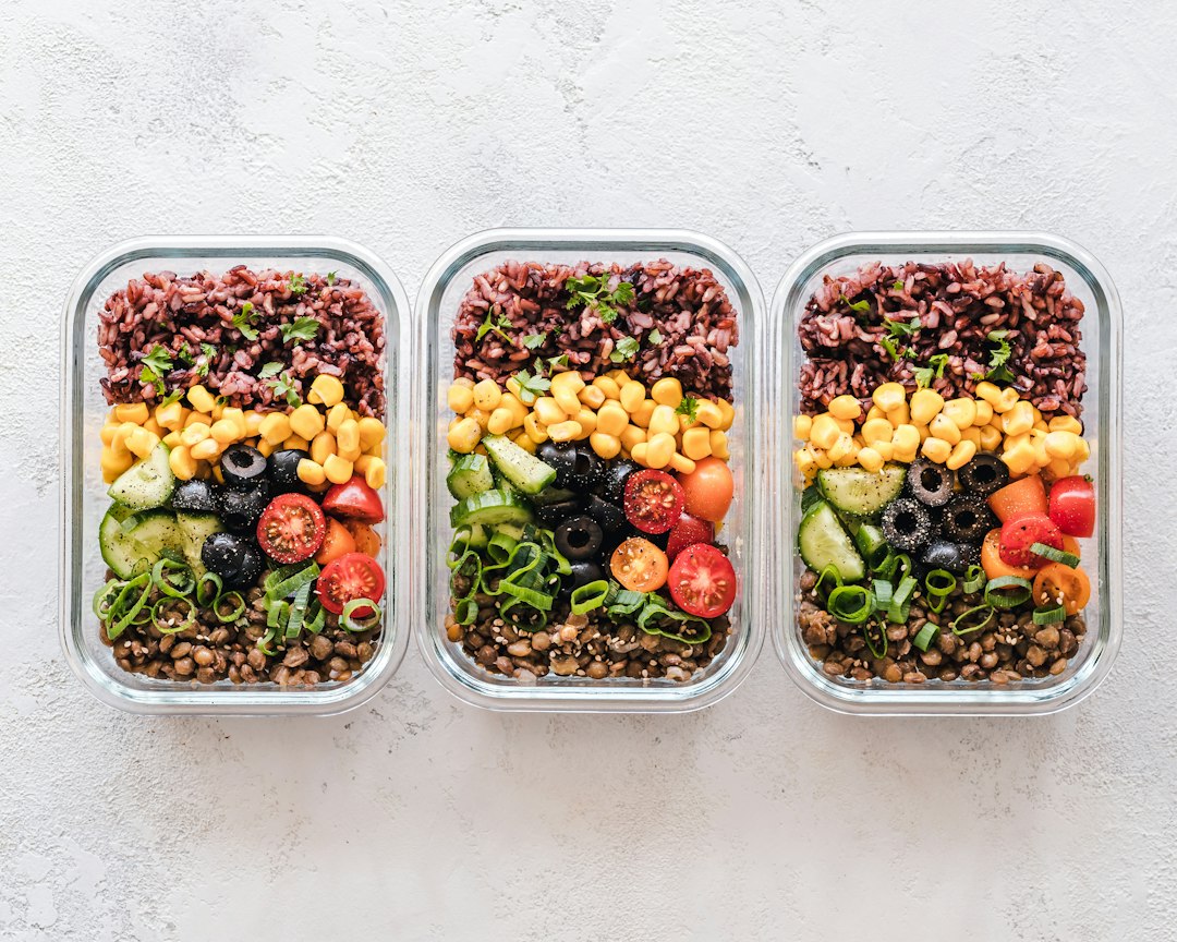 Glass meal prep containers filled with rice, lentils, and vegetables