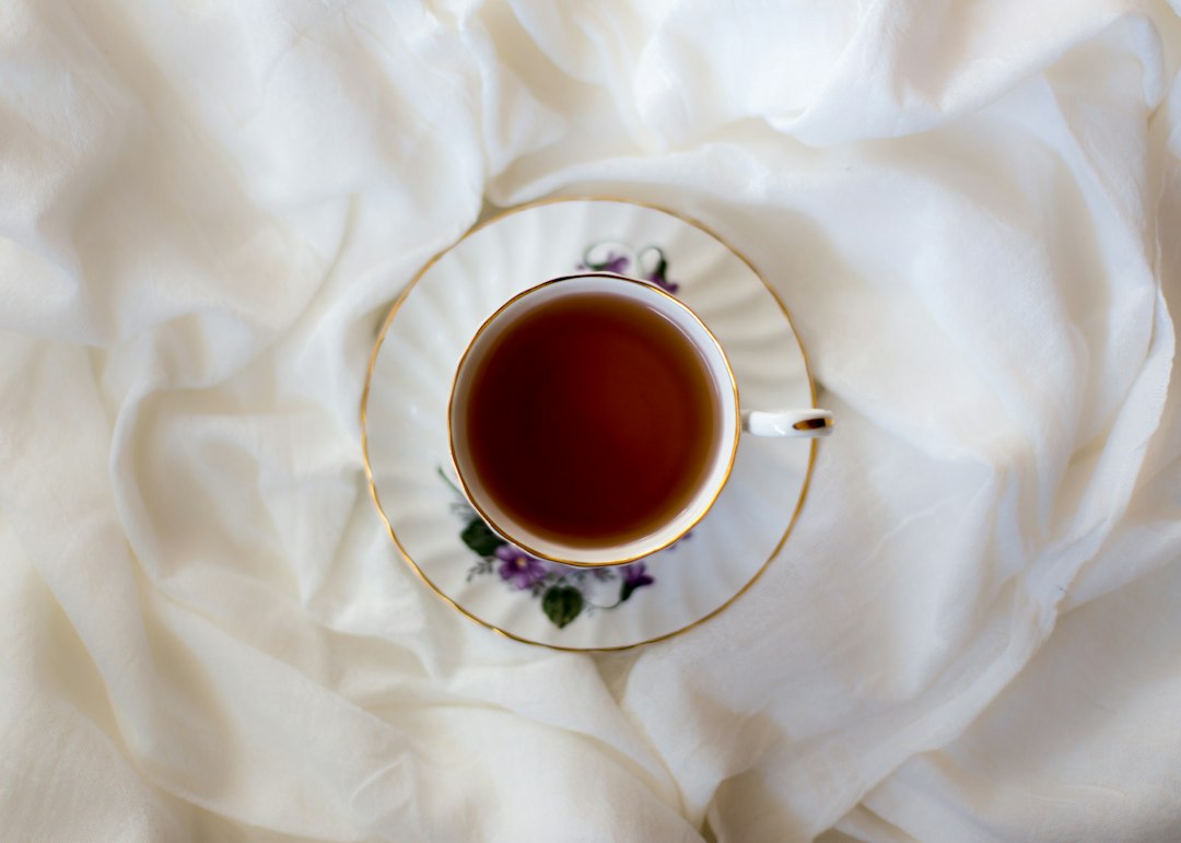 A porcelain teacup filled with freshly brewed tea on a saucer