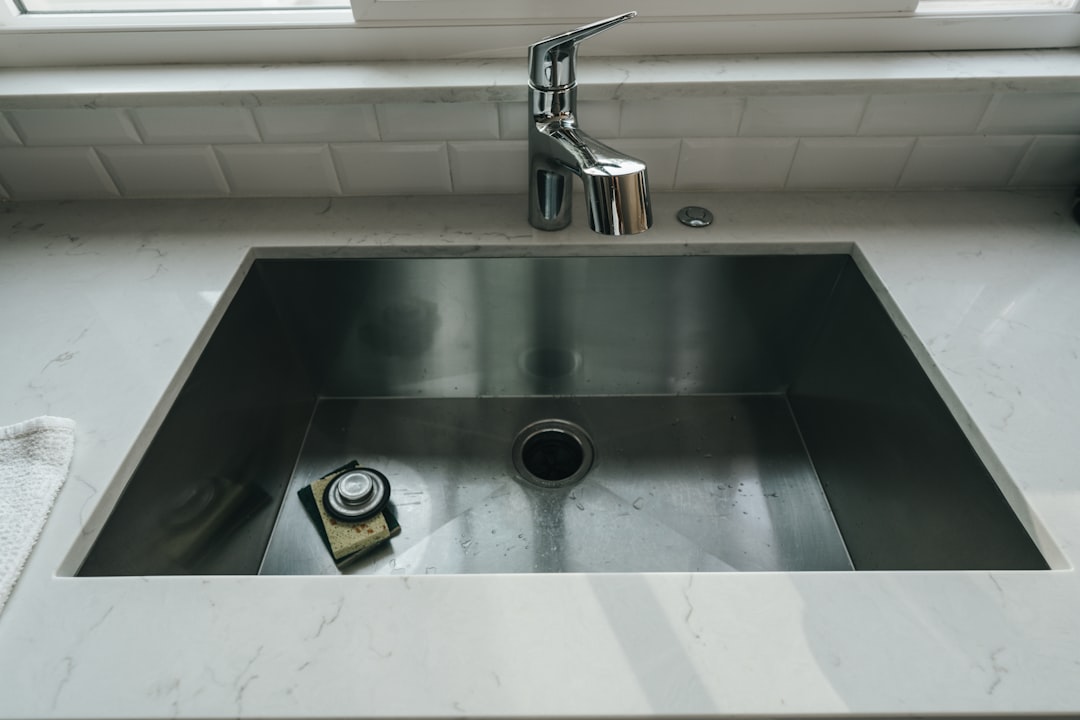 An empty, clean stainless steel kitchen sink at dinnertime