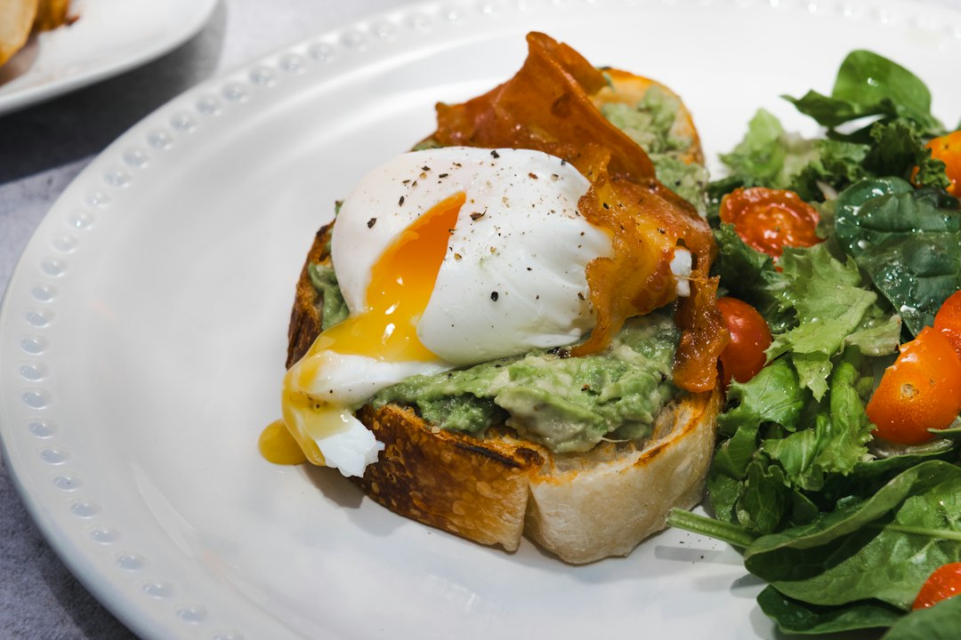 Poached egg with runny yolk on avocado toast