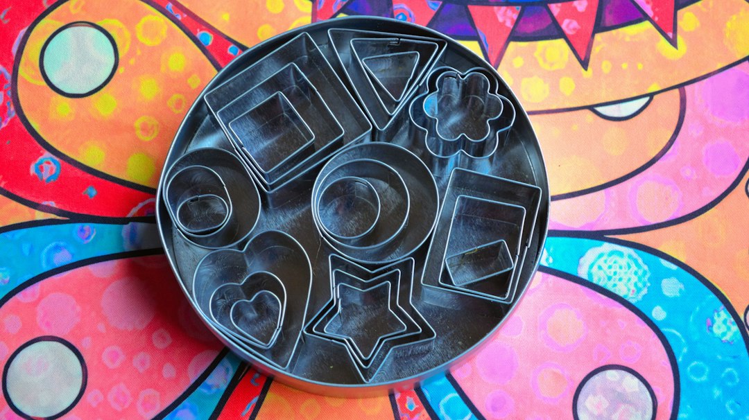 Stainless steel cookie cutters in assorted shapes on a work surface
