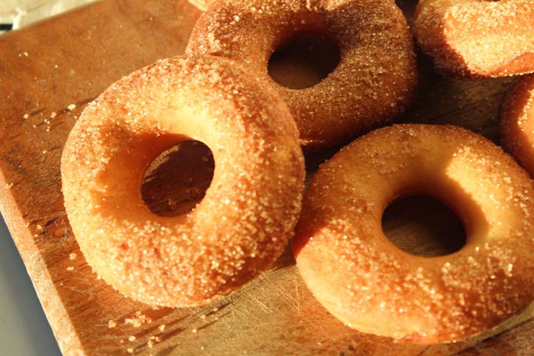 Sugar-dusted cider donuts on a rustic wooden surface