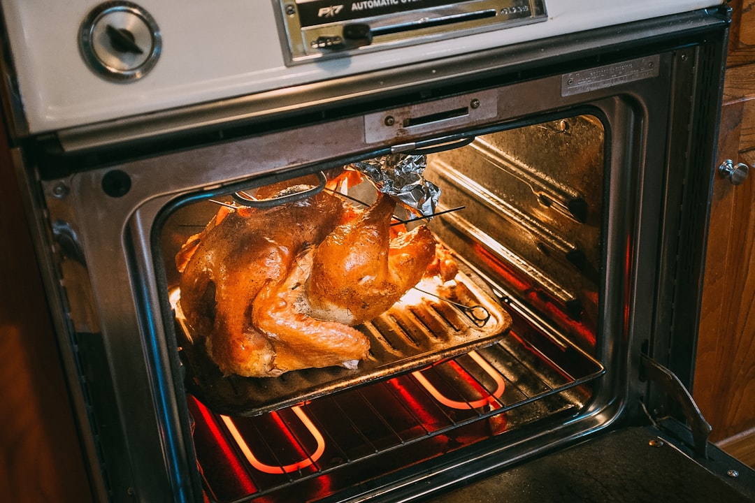 Whole chicken roasting inside an oven on a pan