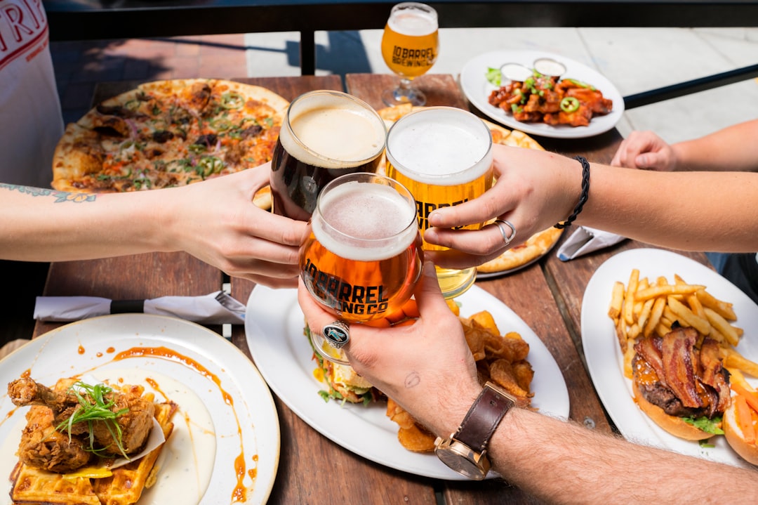 Friends raising heavy beer glasses over a full table