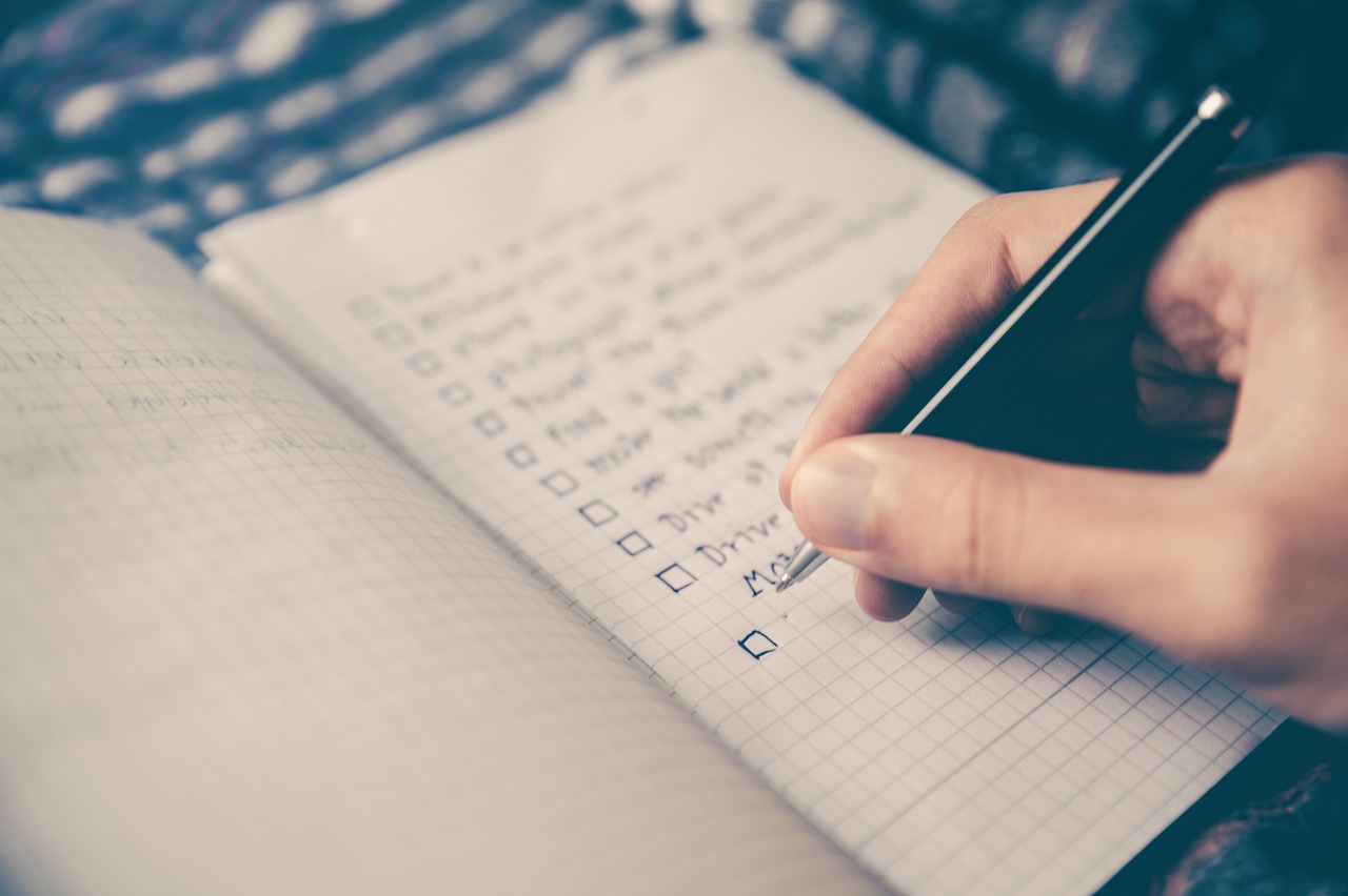 Handwritten checklist in a grid notebook for planning a Thanksgiving turkey thaw schedule