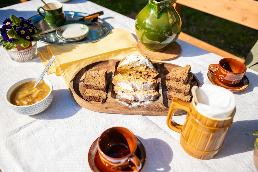 Rustic table set with soup bowls, bread, and mugs for an autumn lunch