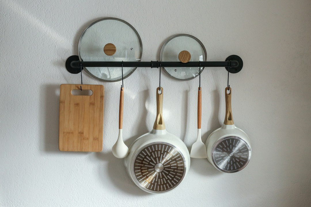 Wall-mounted rack holding cookware within easy reach