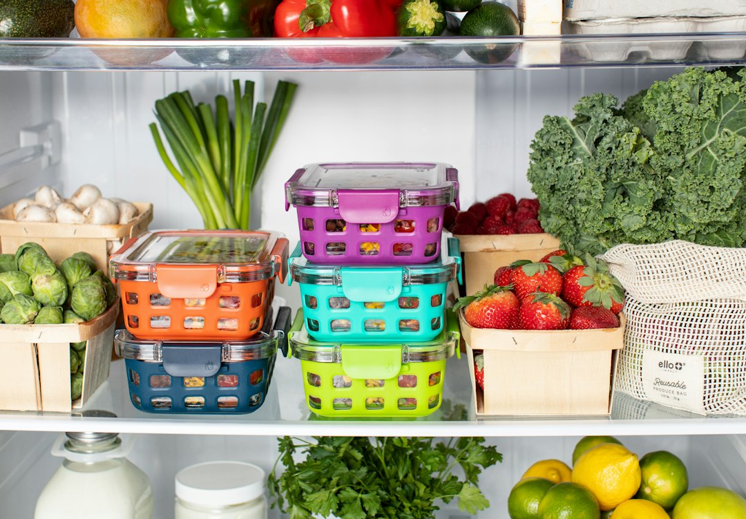 Colorful meal prep containers filled with food organized inside a refrigerator