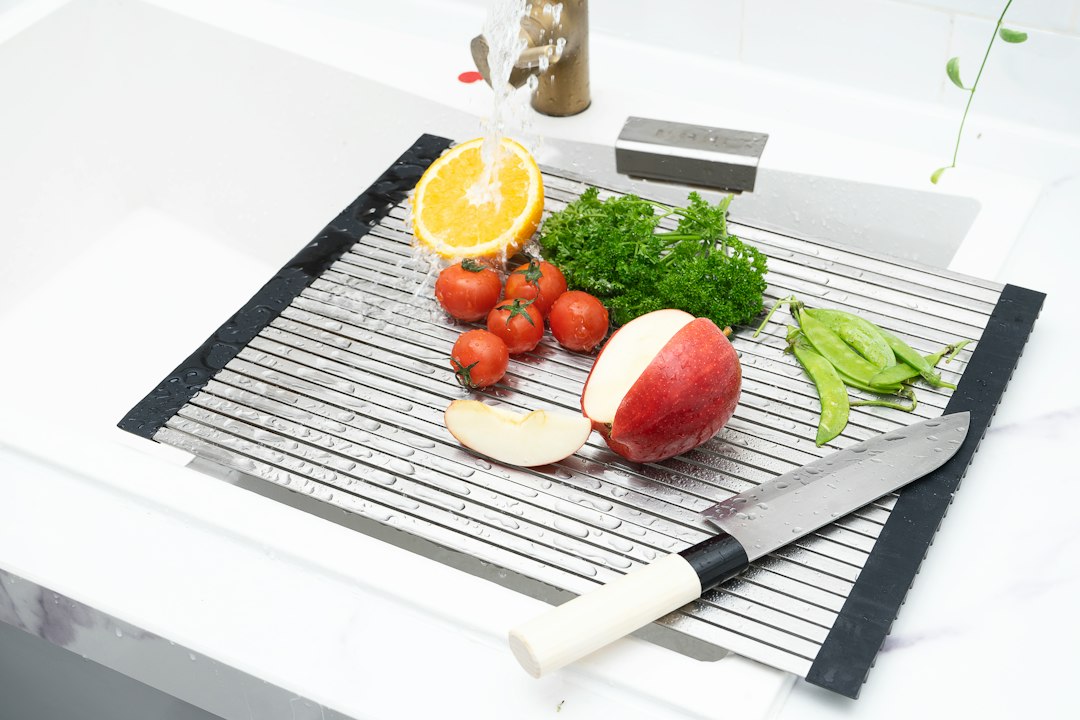 Roll-up dish drying rack stretched over a sink with fresh produce