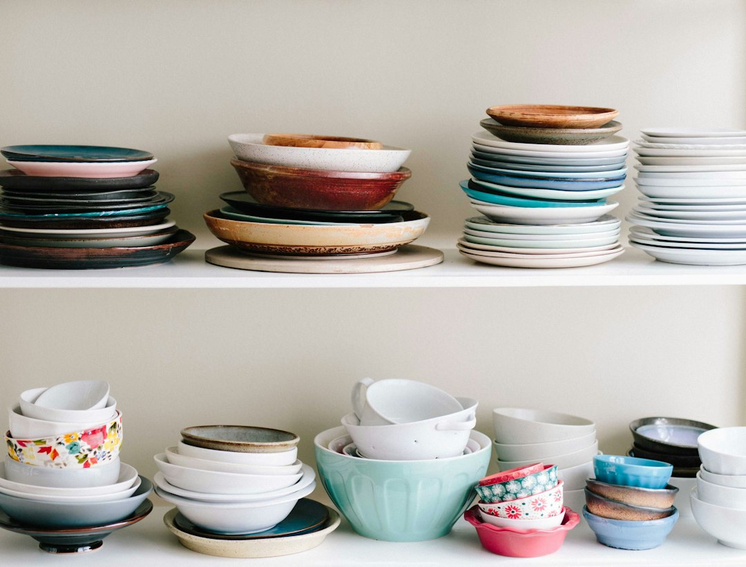 Stacked colorful plates and bowls on open kitchen shelving