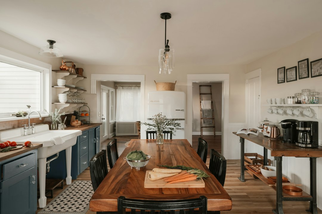 Bright farmhouse kitchen with a white retro refrigerator and a long wooden table set with fresh vegetables