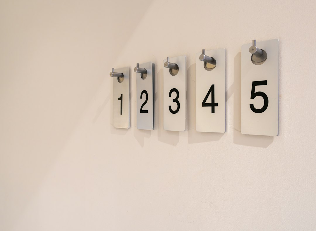 A row of numbered wall hooks, each assigned to one family member for keys and daily carry