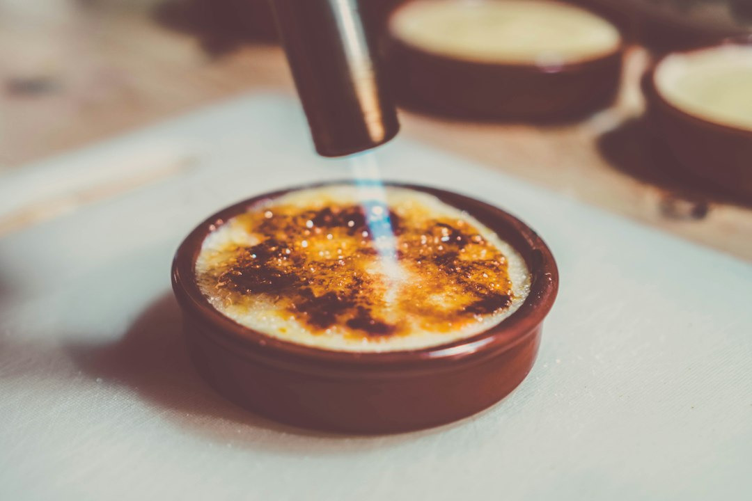 Kitchen torch caramelizing the top of a crème brûlée