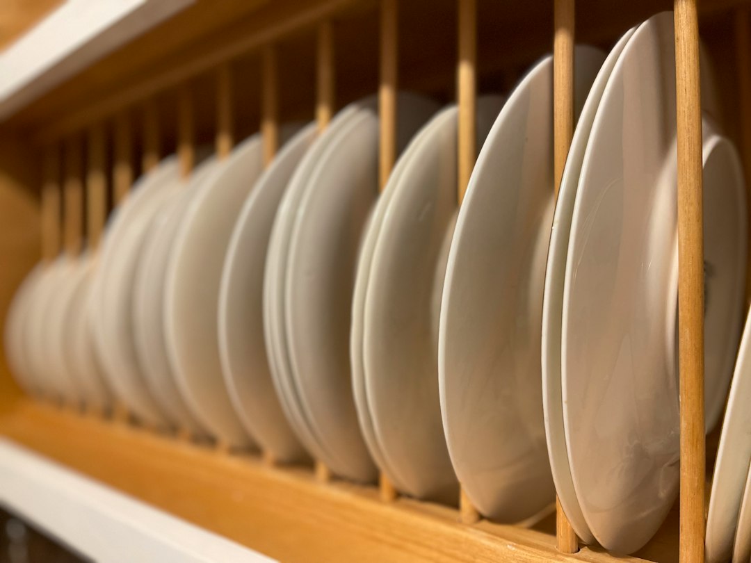 White plates air drying in a wooden dish rack