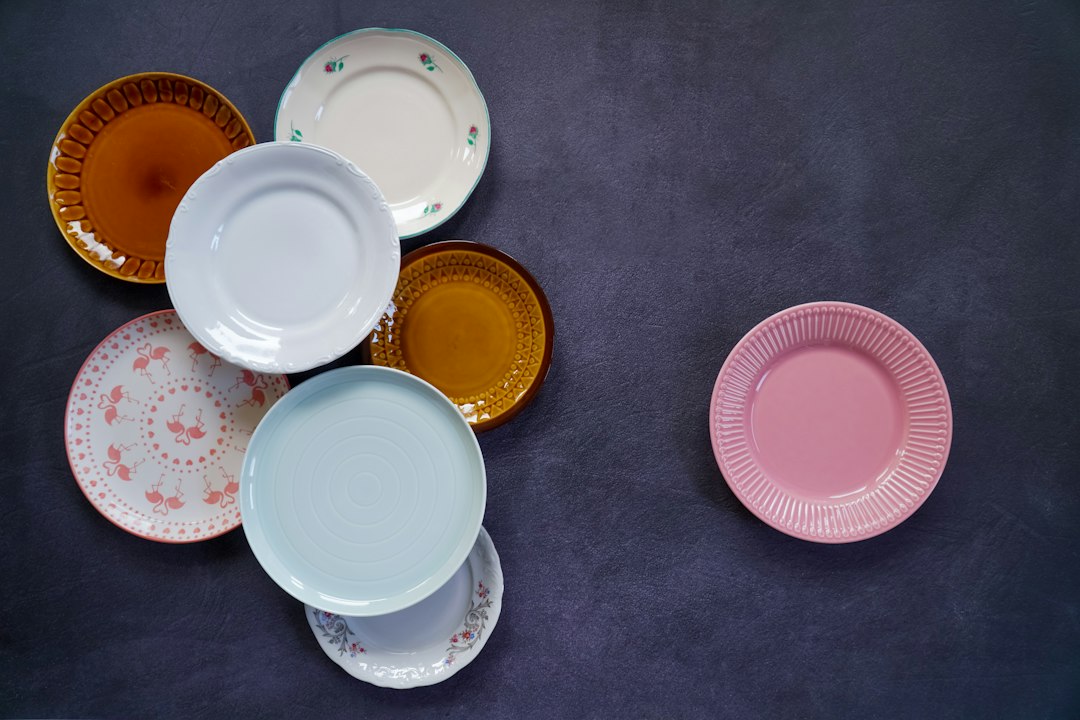 Assortment of mismatched vintage plates in pink, blue, and orange with floral and flamingo patterns