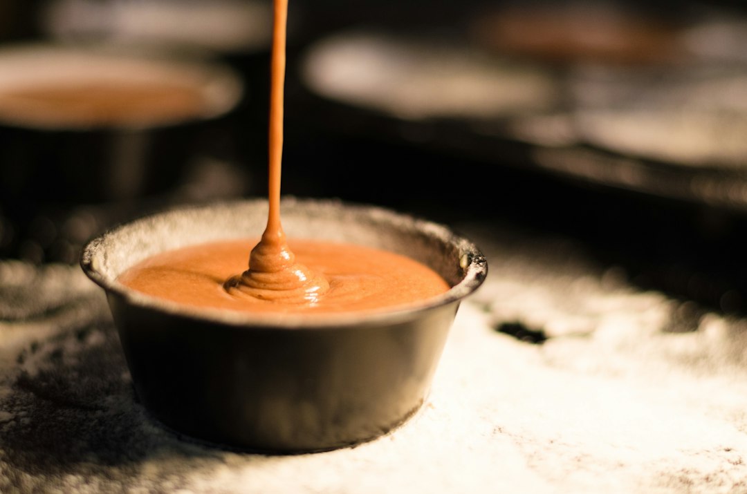 Gravy being whisked into a bowl dusted with flour