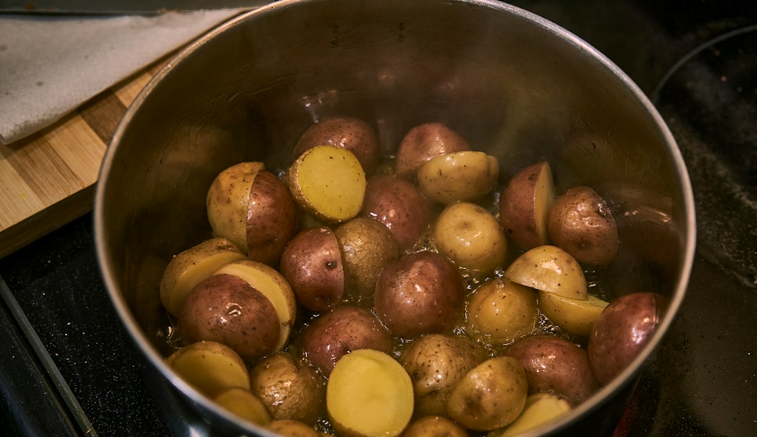 Cut potatoes steaming in a pot on the stove