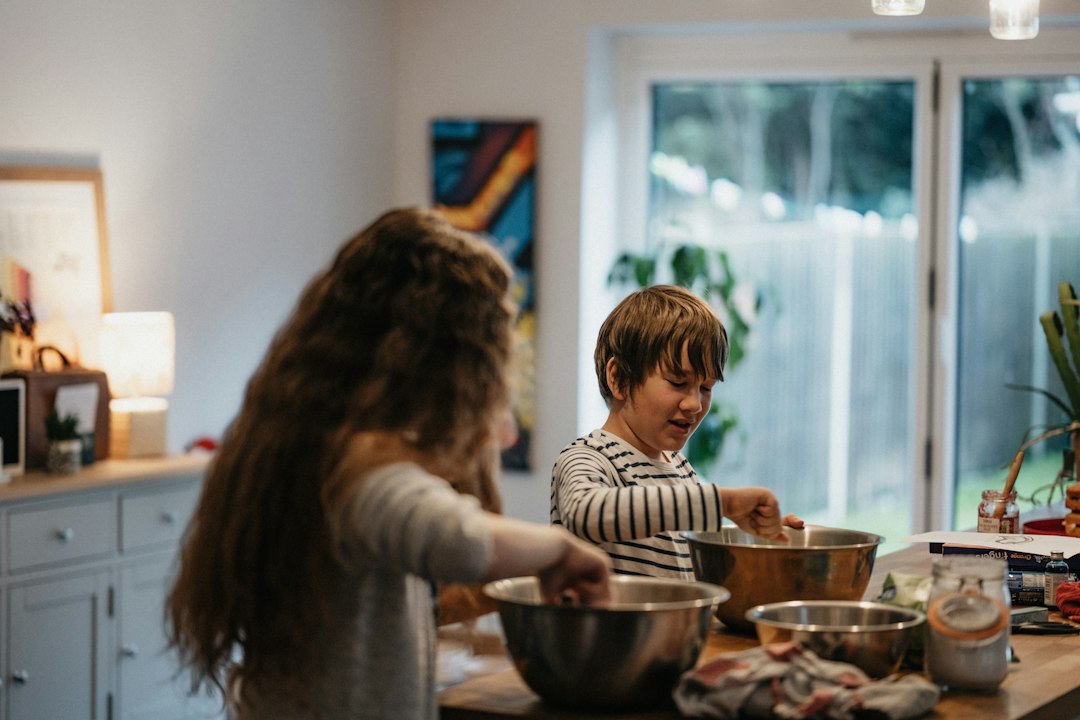 family baking cookies together with mixing bowls on the counter