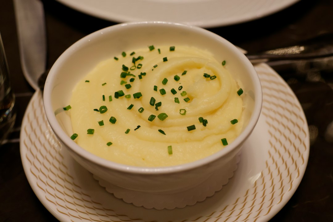 mashed potatoes garnished with chives in a serving bowl
