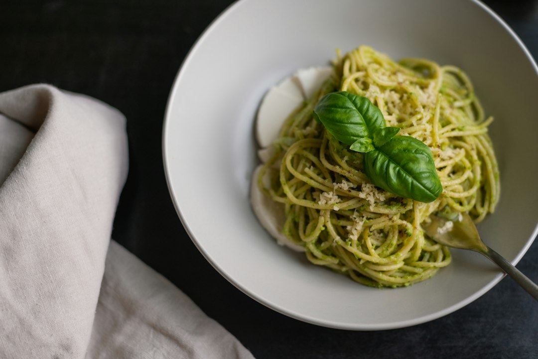 Fresh pesto pasta topped with basil leaves