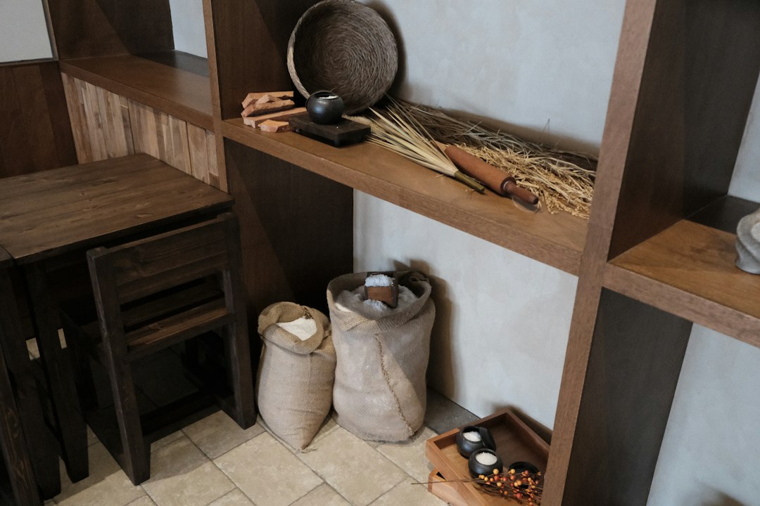 Woven baskets on a wooden shelf holding pantry goods and household papers
