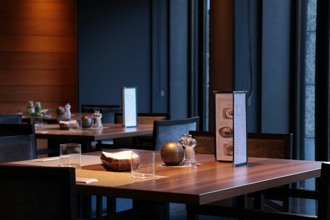 Restaurant table set with water glasses and pepper shakers